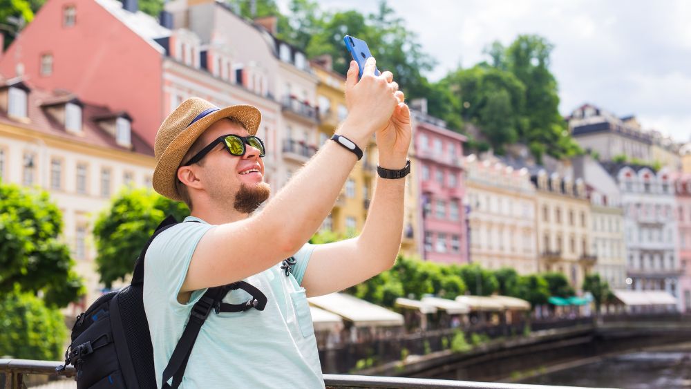 Tourist Using Phone City Travel - HOTEL PARO GRAND Blog